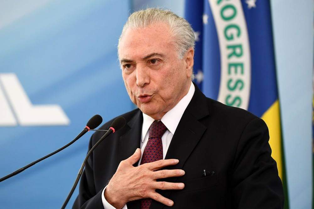 Justiça Federal de Brasília torna Michel Temer réu no inquérito dos portos  Juiz também aceitou denúncia contra ex-assessor da Presidência e empresários; decisão concede prazo para defesas responderem. Em nota, advogado de Temer disse que acusação é 'absurda'.  O juiz federal Marcus Vinicius Reis Bastos aceitou nesta segunda-feira (29) denúncia contra o ex-presidente Michel Temer no chamado inquérito dos portos.  A denúncia original, feita pela Procuradoria-Geral da República em dezembro do ano passado, foi enviada para a primeira instância pelo ministro do Supremo Tribunal Federal Luis Roberto Barroso.  Em nota (leia a íntegra mais abaixo), a defesa de Temer afirma que a acusação é "absurda, sem amparo na prova dos autos".  No último dia 15, o Ministério Público Federal em Brasília confirmou a denúncia da PGR e pediu que o ex-presidente se tornasse réu no caso.  A decisão torna réus, além de Temer, o ex-deputado federal e ex-assessor da Presidência da República Rodrigo Rocha Loures, o amigo pessoal do ex-presidente João Baptista Lima Filho, o Coronel Lima, um sócio de Lima e executivos da empresa Rodrimar, envolvida no inquérito.  Entenda o caso O inquérito foi aberto em 2017, a partir de delações premiadas de executivos da empresa J&F. Para o Ministério Público Federal, o ex-presidente cometeu os crimes de corrupção ativa, corrupção passiva e lavagem de dinheiro ao editar o Decreto 9.048/2017, que tratava do setor portuário.  Os procuradores argumentam que Temer recebeu vantagem indevida de Ricardo Mesquita e Antônio Grecco, da Rodrimar, em troca da edição do decreto que beneficiaria a empresa.  "Houve sucessivas tratativas entre os denunciados por um longo período de tempo e que mantiveram estável vínculo existente com Michel Temer ao longo de sua carreira pública em diversos cargos e que renovaram a promessa de vantagem indevida do agente privado corruptor em troca da atuação funcional do agente público corrupto, neste nicho específico do setor portuário.", dizia a denúncia.  Entre as provas incluídas pelo MPF e citadas pelo juiz na decisão em que aceitou a denúncia e tornou os suspeitos réus estão as delações da J&F, contratos da Rodrimar com a empresa Argeplan, do Coronel Lima, e mensagens trocadas entre Rocha Loures e Ricardo Mesquita.  O juiz concedeu prazo para que as defesas dos agora réus respondam à denúncia e autorizou o compartilhamento das informações do caso com outros inquéritos em investigação na Justiça Federal.  Quando a denúncia foi apresentada pela PGR, Temer afirmou em nota que provará, nos autos judiciais, que "não houve nenhuma irregularidade no decreto dos portos, nem benefício ilícito a nenhuma empresa".  O ex-presidente já é réu em quatro ações penais, denunciado em três inquéritos e investigado em mais cinco casos – ao todo, são 12 procedimentos em São Paulo, no Rio de Janeiro e em Brasília.  Íntegra Leia abaixo a íntegra da nota da defesa de Temer:  Nota  Trata-se de mais uma acusação absurda, sem amparo na prova dos autos. Ao contrário: a Rodrimar, que teria sido beneficiada pelo Decreto dos Portos, não o foi! E isso, repita-se, está provado no inquérito. Infelizmente, ainda será necessário tempo para pôr fim aos danos causados a Temer pelas acusações infundadas que tiveram início numa negociata efetuada com confessos criminosos. Mas dia chegará em que a mentira não produzirá mais notícia, a não ser a de que ela foi desmascarada.
